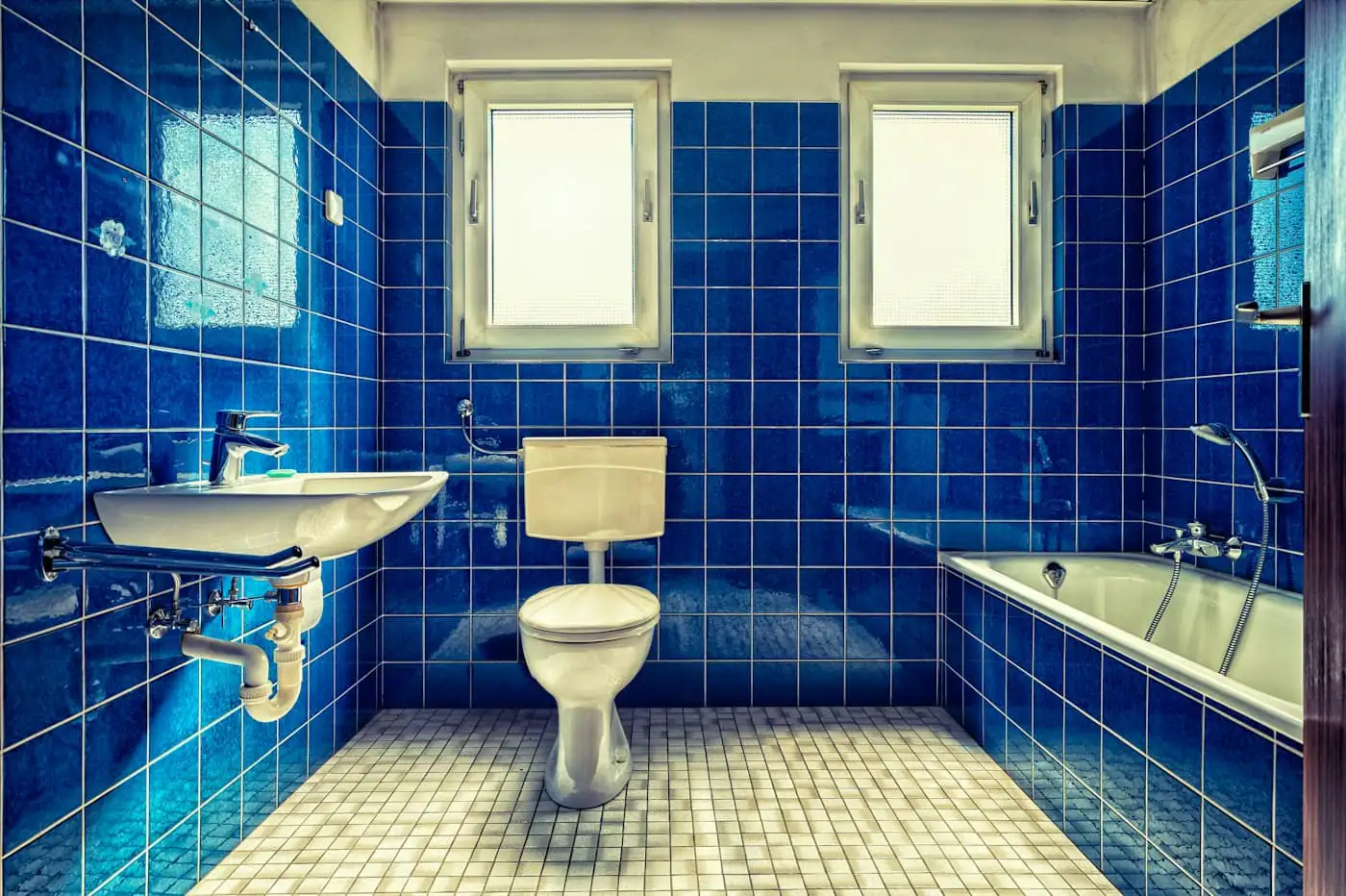 Old bathroom with a bathtub-shower combination and beige tiles