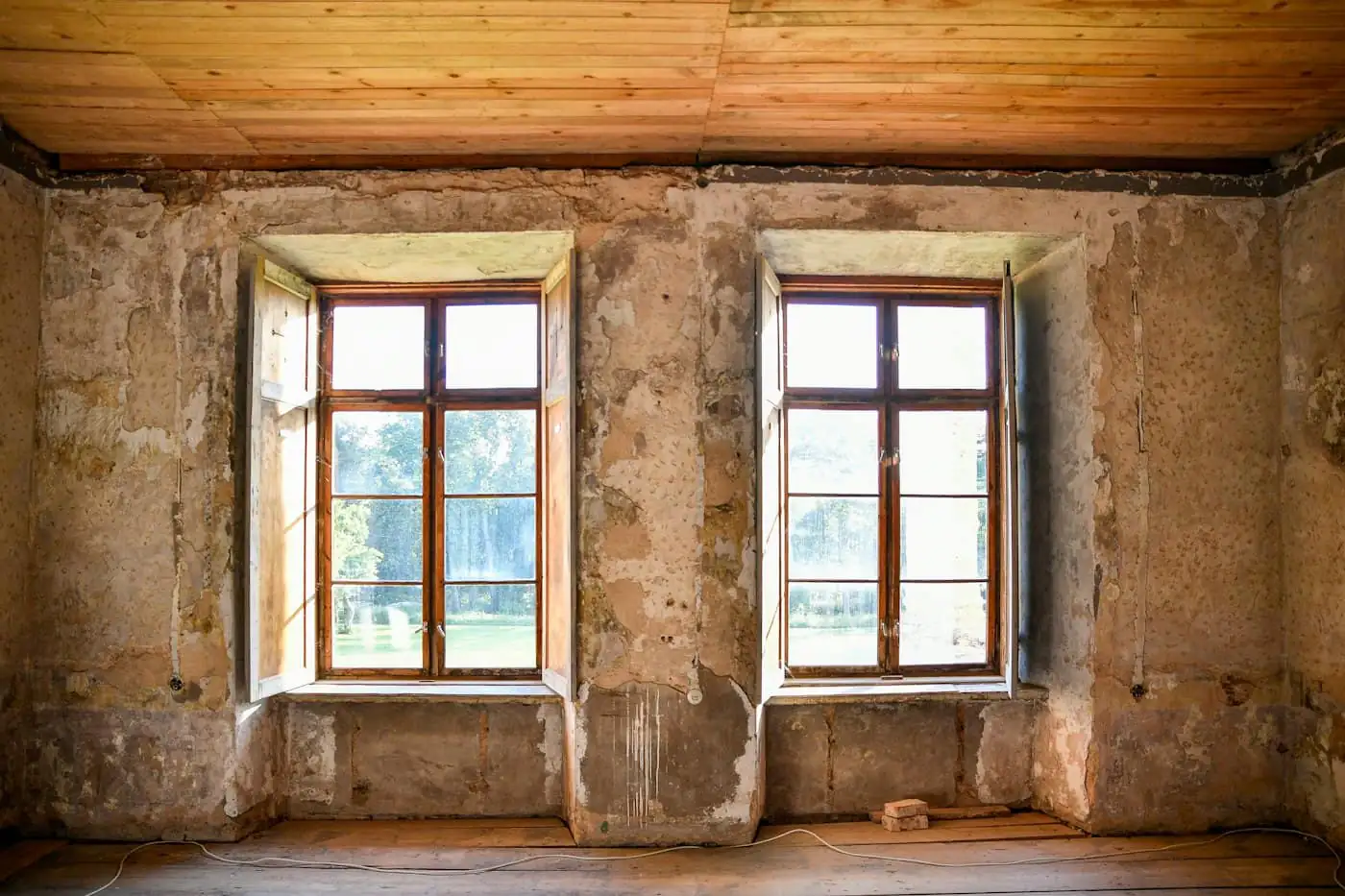 Living room before renovation with worn tiles and old ceiling
